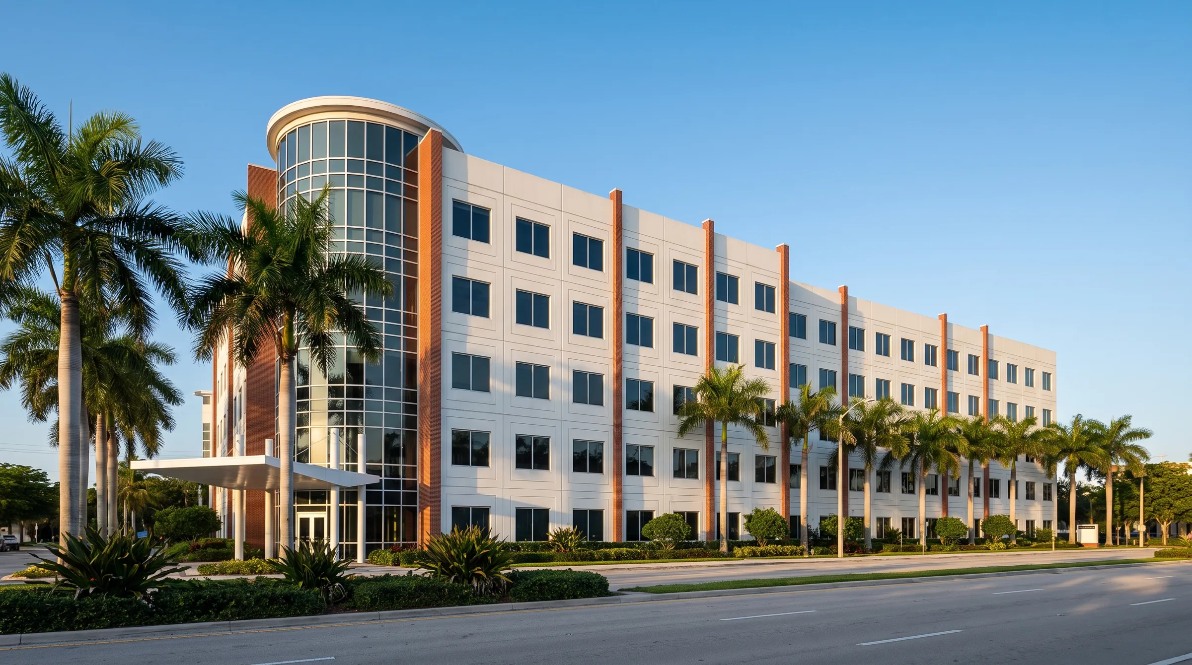 Six-storey white office building with a rounded glass corner tower and royal palms, Downtown Doral