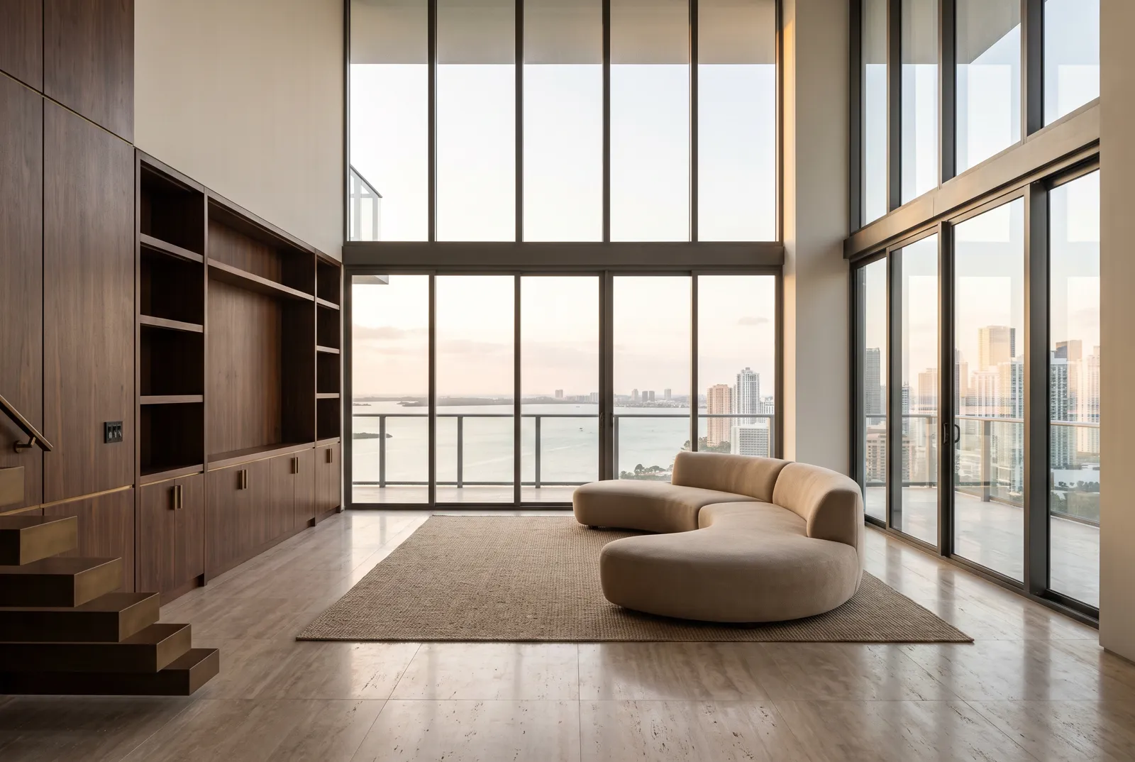 A finished penthouse living room with floor-to-ceiling glass over Biscayne Bay